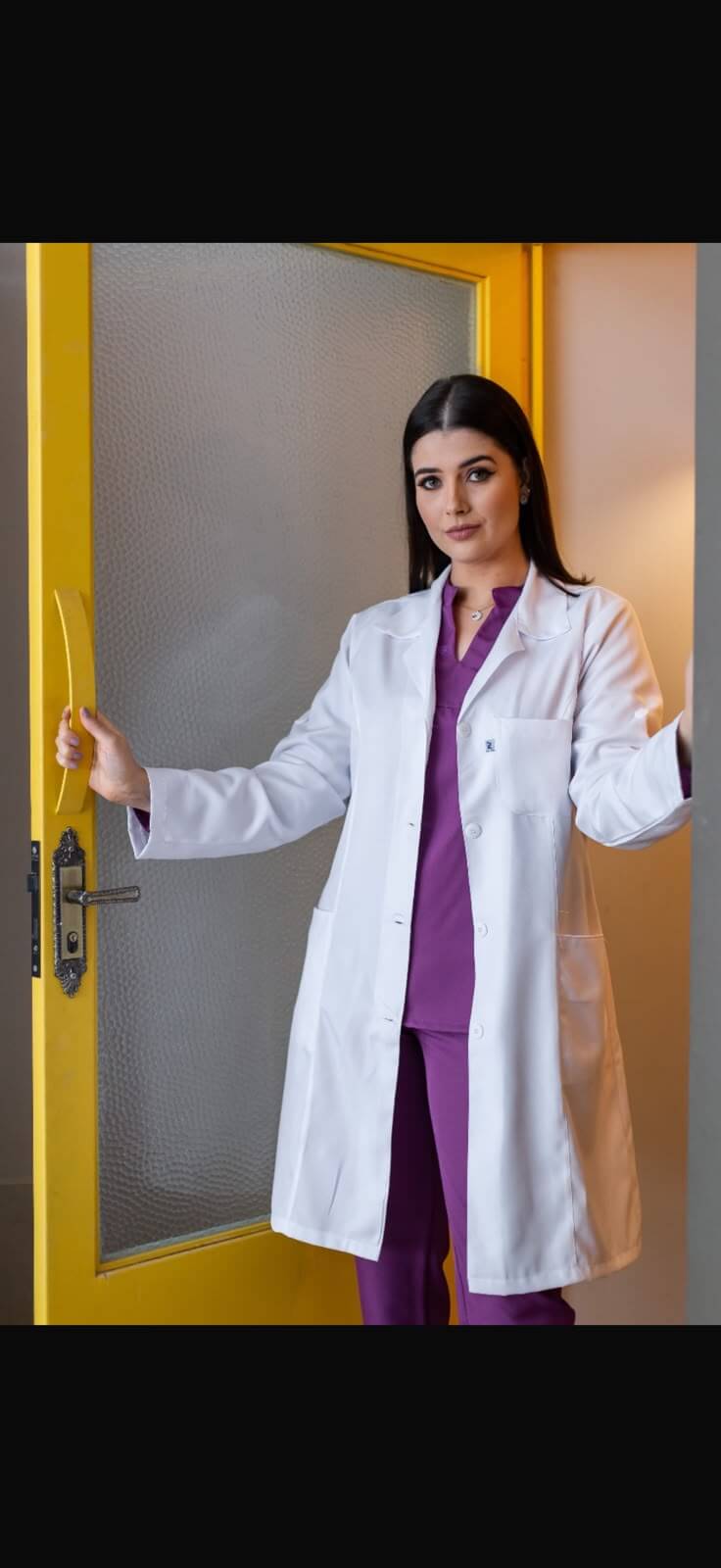Jaleco feminino branco de manga longa sobre scrub roxo